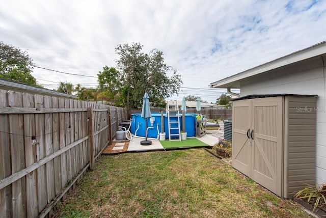 view of yard featuring a fenced in pool and a storage shed