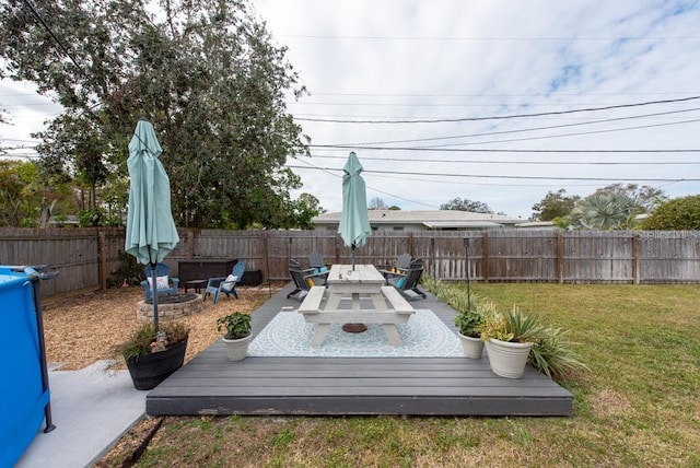 view of yard with a deck and an outdoor fire pit