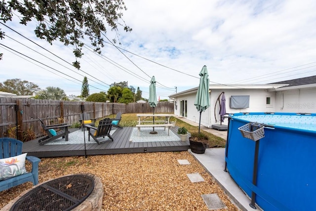 view of yard featuring a swimming pool side deck and a fire pit