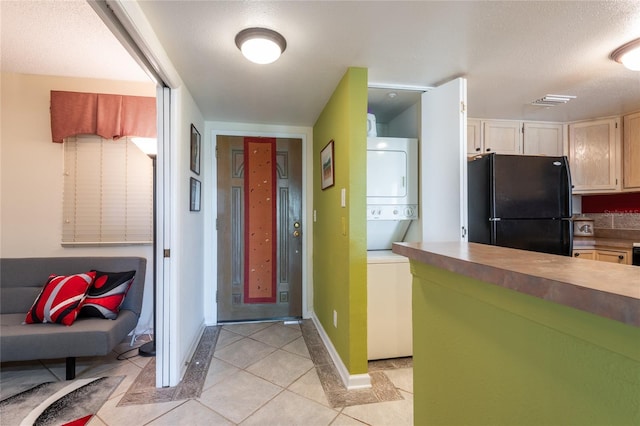 interior space with a textured ceiling and stacked washer / dryer