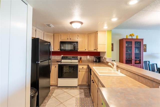 kitchen with light tile patterned floors, light brown cabinets, a textured ceiling, black appliances, and sink