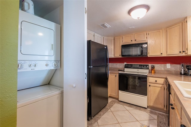 kitchen with black appliances, sink, light tile patterned flooring, stacked washer and dryer, and light brown cabinetry