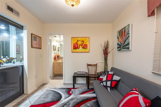 living room with a textured ceiling and light tile patterned flooring