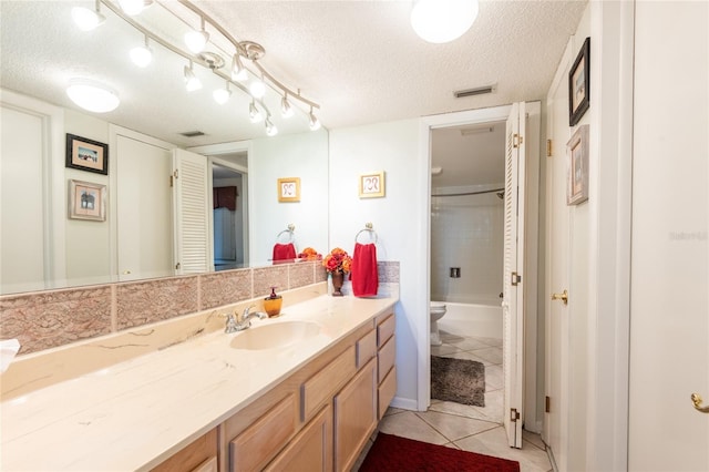 full bathroom featuring tile patterned floors, a textured ceiling, enclosed tub / shower combo, and vanity