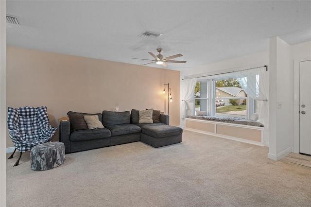 carpeted living room with ceiling fan