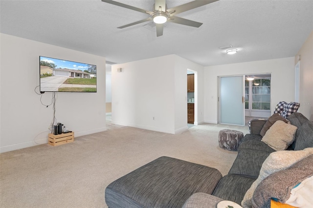 living room featuring a textured ceiling, ceiling fan, and light colored carpet