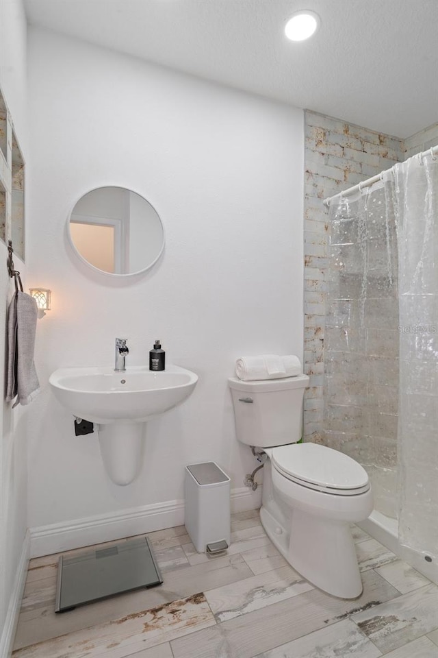 bathroom featuring toilet and curtained shower