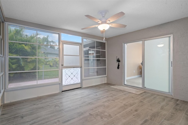 unfurnished room with ceiling fan, a textured ceiling, and light hardwood / wood-style floors