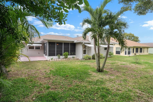 back of property featuring a sunroom, a lawn, and a patio