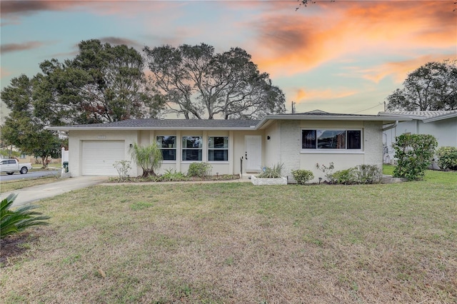 single story home with a garage and a lawn