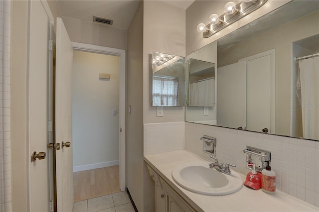 bathroom with tasteful backsplash, tile patterned floors, and vanity