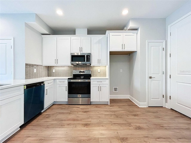 kitchen featuring stainless steel appliances, decorative backsplash, light hardwood / wood-style flooring, and white cabinets