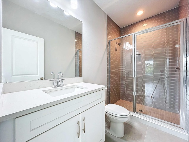 bathroom featuring toilet, tile patterned floors, an enclosed shower, and vanity