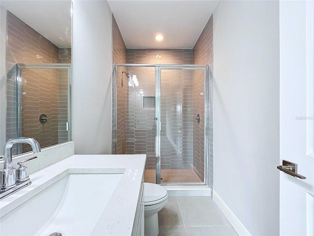 bathroom with a shower with door, tile patterned floors, toilet, and vanity