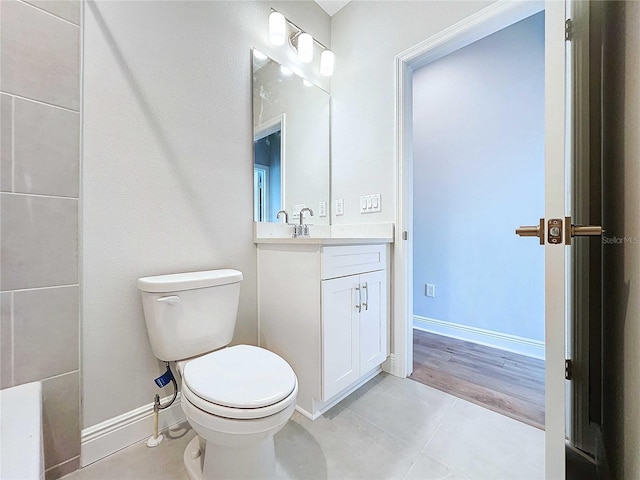 bathroom with toilet, vanity, and tile patterned flooring