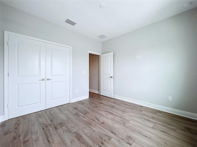 unfurnished bedroom with a closet and light hardwood / wood-style floors