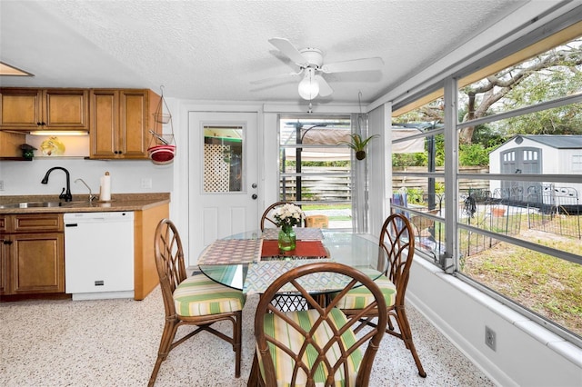 sunroom with ceiling fan, sink, and a wealth of natural light