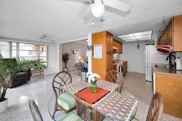 dining space featuring sink and a textured ceiling