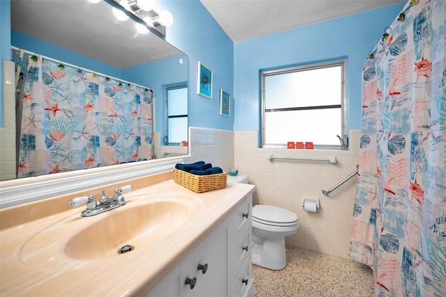 bathroom featuring plenty of natural light, tile walls, toilet, and vanity