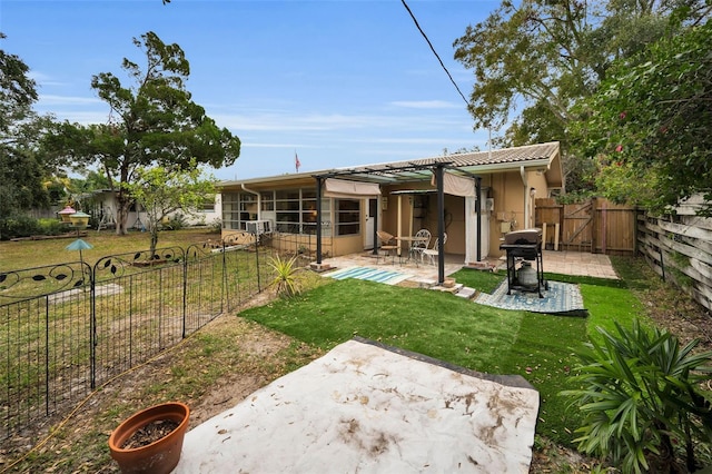 rear view of property with a lawn and a patio