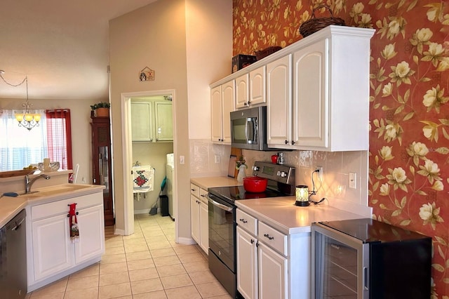 kitchen with wine cooler, sink, black appliances, and white cabinets