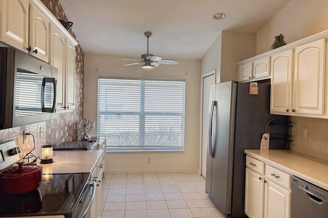 kitchen with backsplash, light tile patterned floors, ceiling fan, stainless steel appliances, and a textured ceiling