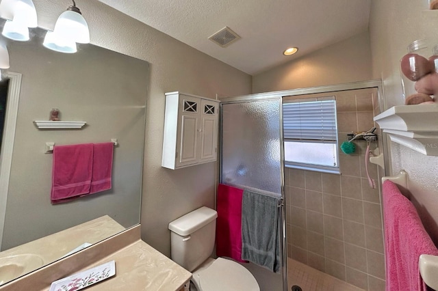 bathroom featuring vanity, vaulted ceiling, a shower with shower door, and toilet