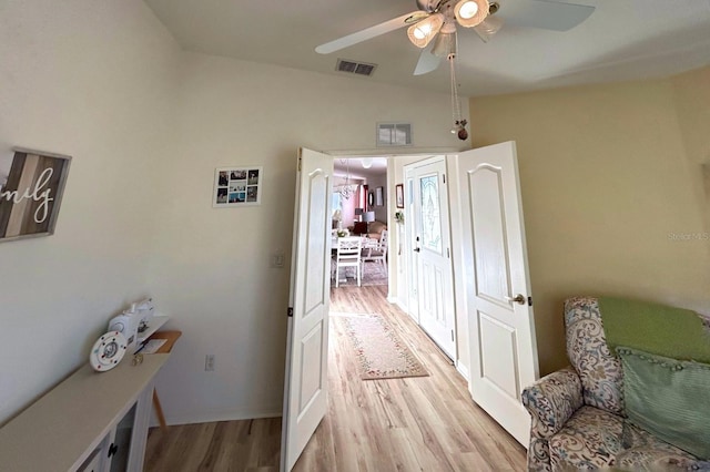 corridor featuring vaulted ceiling and light hardwood / wood-style flooring