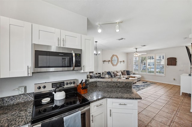 kitchen with ceiling fan with notable chandelier, white cabinets, stainless steel appliances, dark stone countertops, and light tile patterned floors