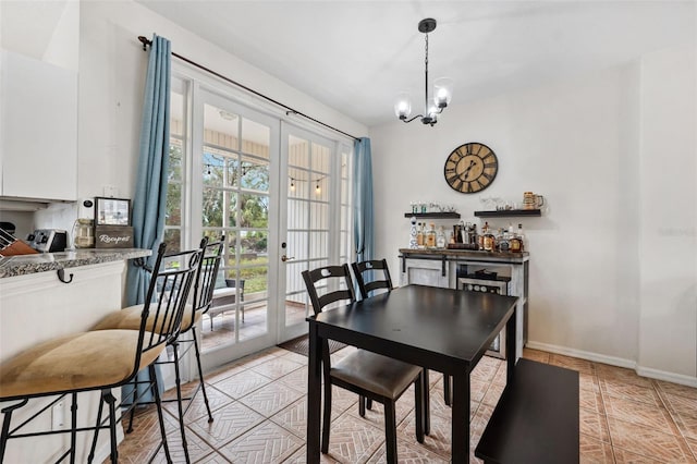 dining room featuring light tile patterned floors, a chandelier, and french doors