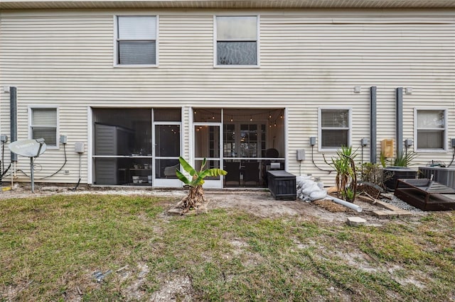 back of property featuring central air condition unit, a yard, and a sunroom