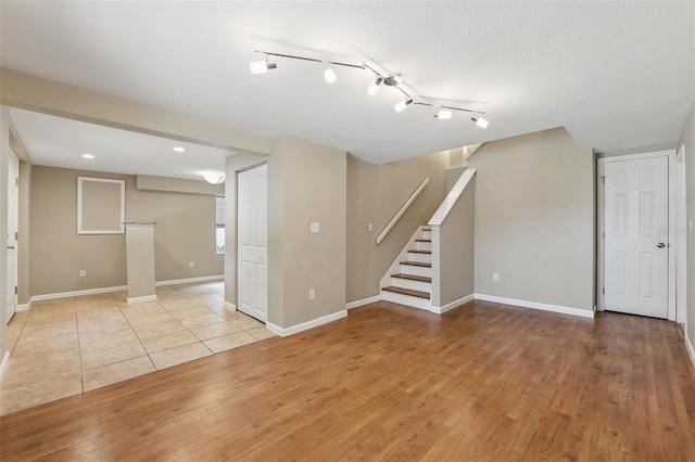 interior space with stairway, baseboards, and light wood finished floors