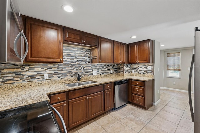 kitchen with a sink, backsplash, light tile patterned floors, and appliances with stainless steel finishes