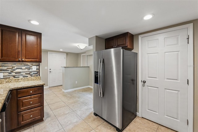 kitchen featuring stainless steel appliances, baseboards, decorative backsplash, light tile patterned flooring, and light stone counters