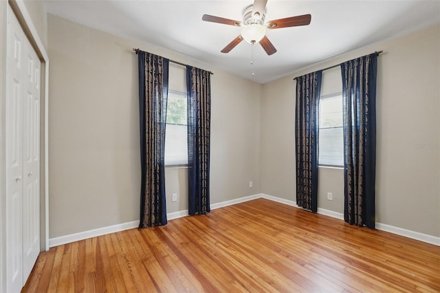spare room with baseboards, a ceiling fan, and light wood-type flooring