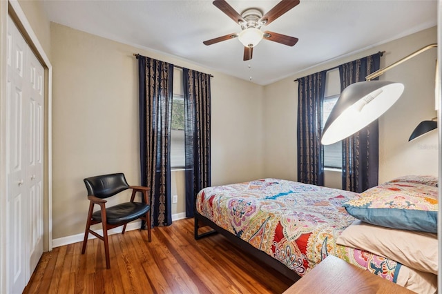 bedroom featuring a closet, baseboards, ceiling fan, and wood finished floors