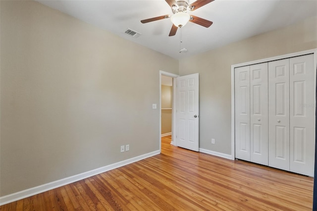 unfurnished bedroom with a closet, light wood-style flooring, baseboards, visible vents, and ceiling fan