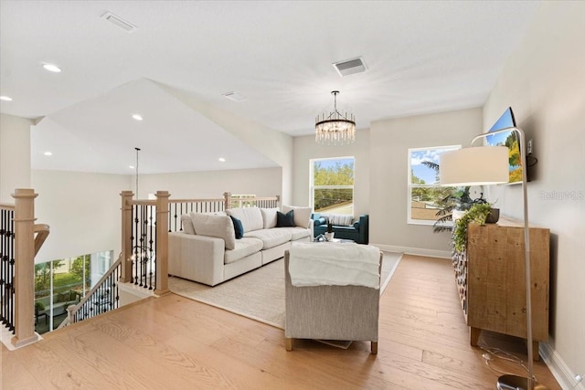 living room featuring light wood-type flooring and a chandelier