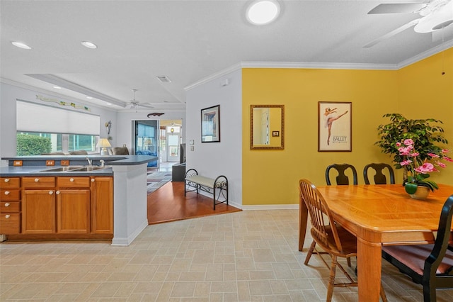 kitchen with ceiling fan, stovetop, a raised ceiling, and crown molding