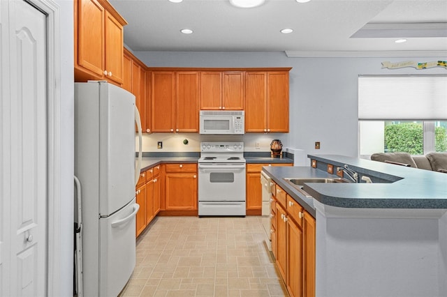 kitchen featuring sink, a kitchen island with sink, a tray ceiling, and white appliances