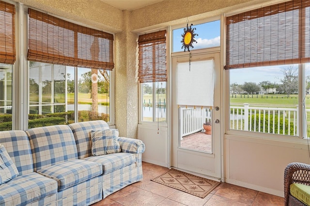 sunroom / solarium featuring a water view