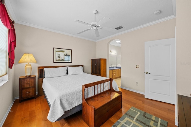 bedroom with ceiling fan, ensuite bathroom, light hardwood / wood-style flooring, and crown molding