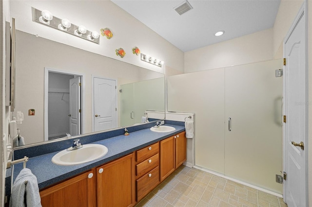 bathroom with vanity and a shower with door