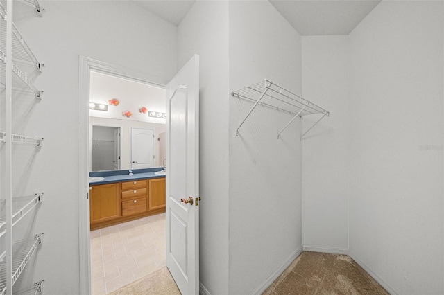 spacious closet featuring light colored carpet