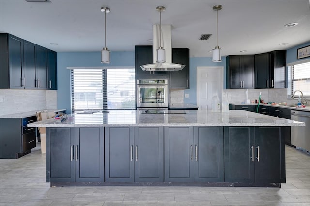 kitchen featuring decorative light fixtures, light stone countertops, stainless steel appliances, and a kitchen island