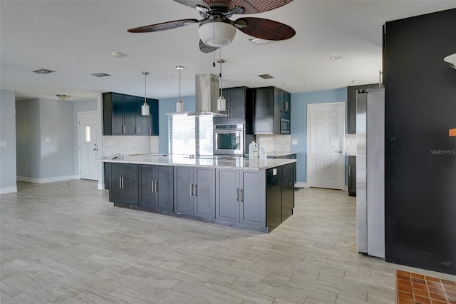 kitchen featuring tasteful backsplash, hanging light fixtures, light stone countertops, appliances with stainless steel finishes, and island range hood