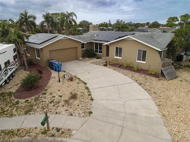 single story home featuring solar panels and a garage