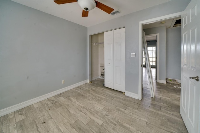 unfurnished bedroom with light wood-type flooring, ceiling fan, and a closet