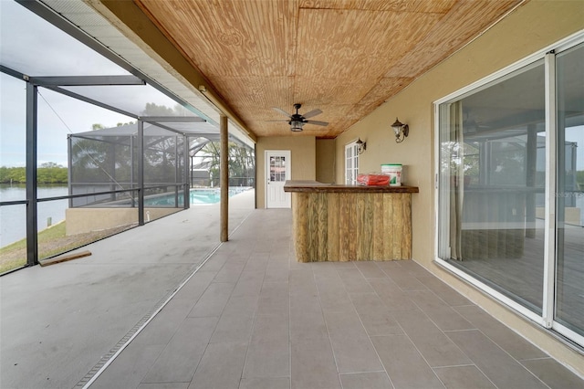 unfurnished sunroom with wooden ceiling, a water view, and ceiling fan