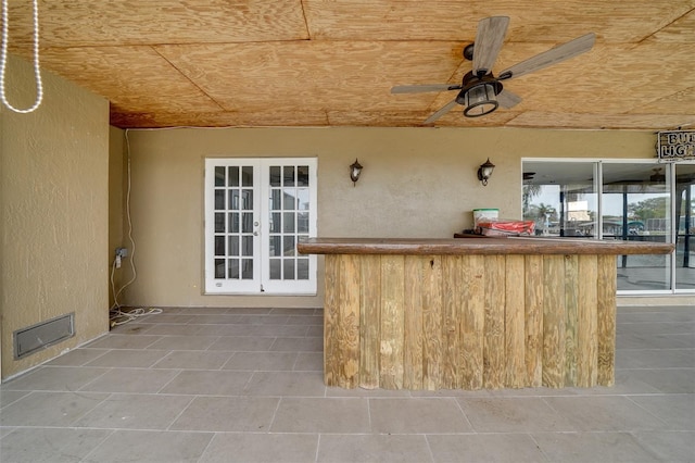 view of patio / terrace featuring ceiling fan, french doors, and a bar